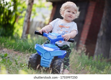 Baby Boy Is Riding A Toy Car Quad Bike.