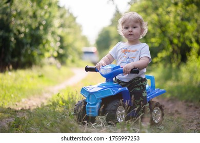 Baby Boy Is Riding A Toy Car Quad Bike.