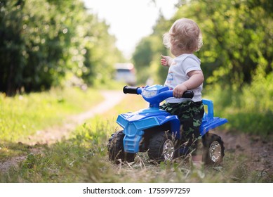 Baby Boy Is Riding A Toy Car Quad Bike.