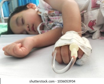 Baby Boy Sick And Sleeping On Patient Bed At The Hospital. Saline Intravenous Or (IV)drip In Baby Patient Hand. Poor Baby Looks Tired And Exhausted.IV Fluid Replacement Or Correcting The Dehydration.