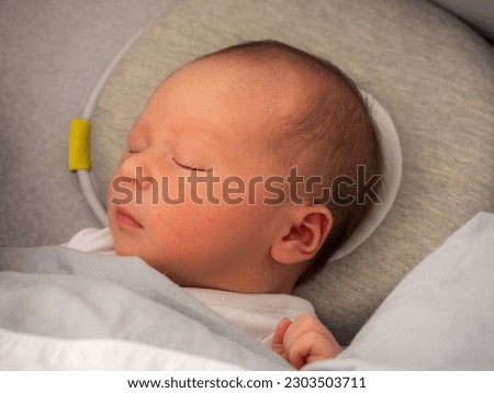 A baby boy sleeping on the bed, an infant sleeps, Plagiocephaly Pillow, flat head pillow