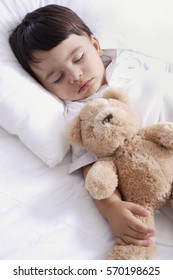 baby boy sleeping with teddy bear