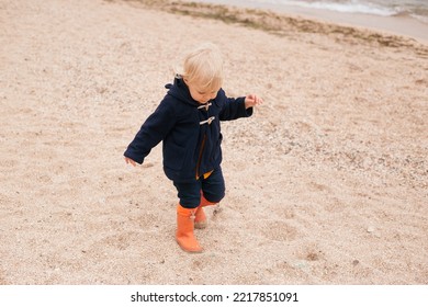 Baby Boy Walking On The Beach Near Sea In Autumn Or Summer Time