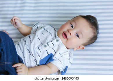 Baby Boy In White Shirt Has A Crafty Face And Eye