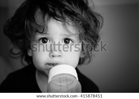 Baby boy/toddler, sucking a bottle of milk. Shallow DOF Black and White