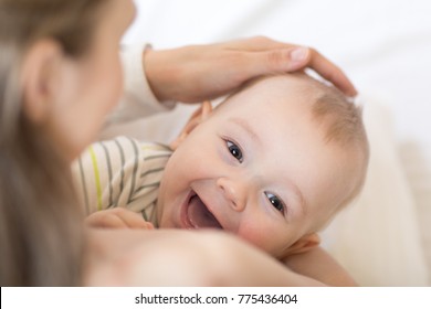 Baby breastfeeding. Mother holding her newborn child. Little kid boy laughing and looking at camera