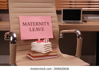 Baby care accessories, notebooks and note with text Maternity Leave on office chair indoors