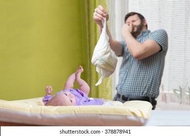 Baby Care Concept. Father Od Dad Is Changing Stinky Diaper.