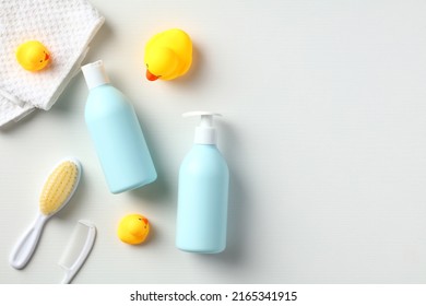 Baby Care Products On White Table Top View. Flat Lay Daily Baby Care Products, Shampoo, Body Wash Bottles For For Bathing With Yellow Rubber Ducks.