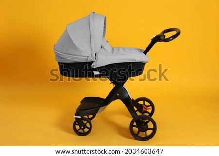 Baby carriage. Modern pram on yellow background