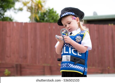 Baby Caucasian Girl Toddler Dressing Up Playing In Police Uniform Grinning With Joy And Happiness In Childhood Play