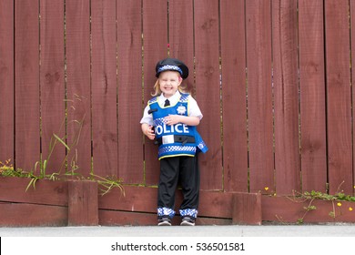 Baby Caucasian Girl Toddler Dressing Up Playing In Police Uniform Grinning With Joy And Happiness In Childhood Play