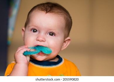 Baby Chewing On Teething Ring Toy