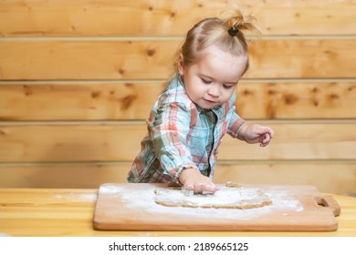 Baby Child Boy In The Kitchen Helping With Cooking, Playing With Flour. Little Boy Child Laying On Very Messy Kitchen Floor, Covered In White Baking Flour.