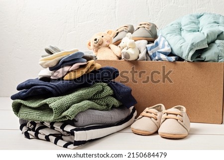 Baby and child clothes, toys in box. Second hand apparel idea. Circular fashion, donation, charity concept