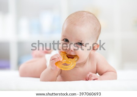 baby child lying on belly weared diaper with teether