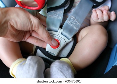 Baby Child Sitting In Car Seat With Safety Belt Locked Protection