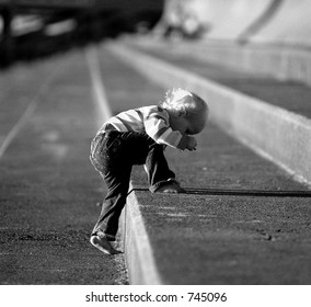 Baby Climbing Up Stone Steps In Black And White