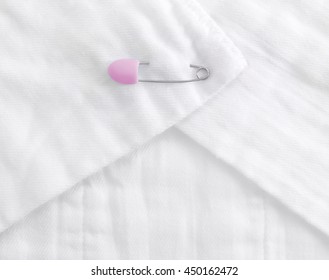 Baby cloth diaper with a pink safety pin - Powered by Shutterstock