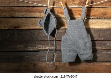 baby clothes, hung on a clothesline with wooden hooks, overalls and hat. clothes are drying in the shade. copy space. cleaning concept. hand crochet knitted. - Shutterstock ID 2194765047