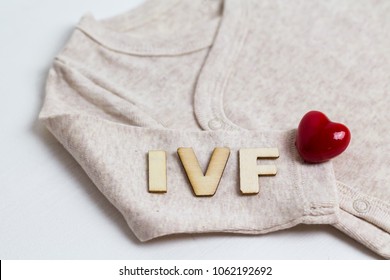 Baby Clothes With Test-tube And Heart. Concept - IVF, In Vitro Fertilization. Waiting For Baby, Pregnant.