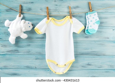 Baby clothes and white bear toy on a clothesline