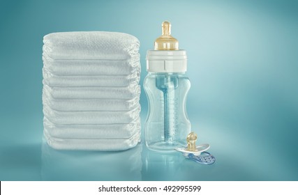 Baby Concept Background. Stack Of Diapers. Baby Bottle And Pacifier. Studio Shot. Isolated