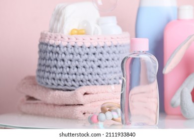 Baby Cosmetic Products, Toys And Accessories On White Table Against Pink Background