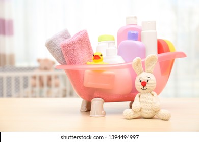 Baby Cosmetic Products, Toys And Towels On Table Indoors