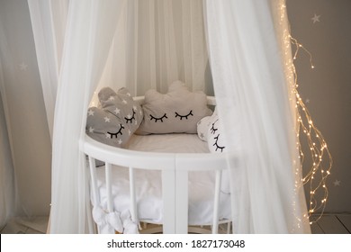 a baby cot with fabric top and garland