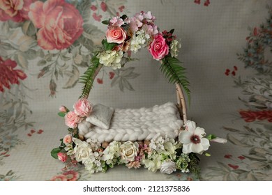 baby cot for a photo shoot of newborns. props for a photo shoot. the bed is decorated with pink roses. furniture for dolls