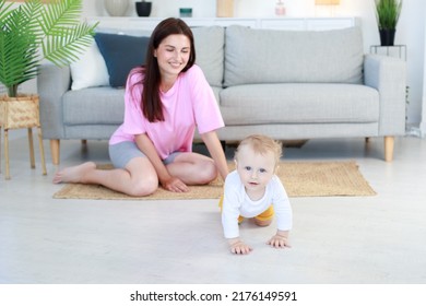 The Baby Crawls Away From Mom In The Living Room.