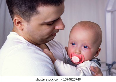 The Baby Is Crying In The Arms Of Dad.