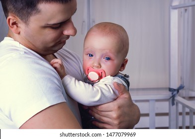 The Baby Is Crying In The Arms Of Dad.