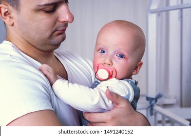 The Baby Is Crying In The Arms Of Dad.