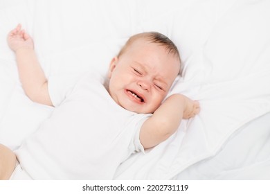 The Baby Is Crying In His Crib . The Baby 's Teeth Are Teething . Colic In Babies . Hungry Baby . Baby On A White Background