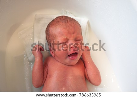 Similar – Newborn in the bathtub with her mother washing her hair