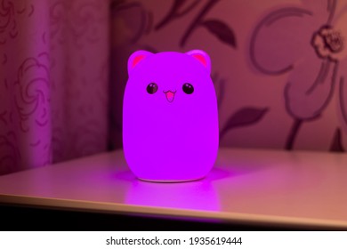 The Baby Cute Bear-shaped Purple Night Lamp With Eyes And Ears On The Bedside Table In The Pink-style Room Glows In The Dark