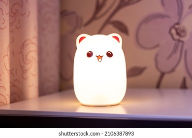 The Baby Cute Bear-shaped White Night Lamp With Eyes And Ears On The Bedside Table In The Pink-style Room Glows In The Dark