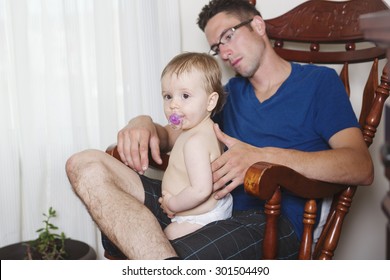 A Baby With Dad Relax On The Chair