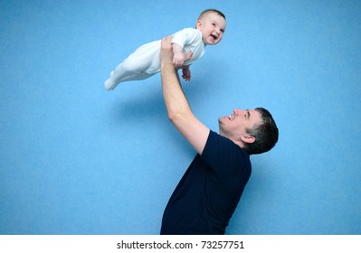 Baby in the daddy hands. Blue background.