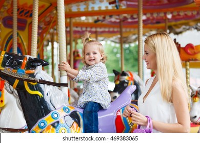 The Baby Daughter With Her Mother On The Carousel