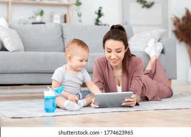 Baby Development Apps. Cute Toddler Boy And His Mom Playing With Digital Tablet At Home, Relaxing On Floor In Living Room Together, Free Space - Powered by Shutterstock