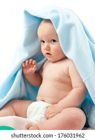 A Baby In A Diaper With A Blue Blanket Draped Over His Head.