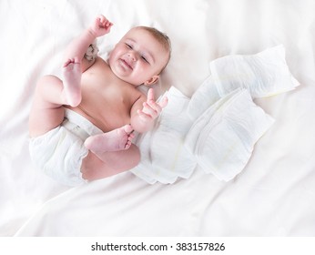 Baby in diaper on a white background with a branch of cotton