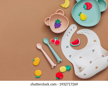 baby dishware on brown background, Flat lay composition with kids accessories, first food for baby, first feeding concept - Shutterstock ID 1932717269