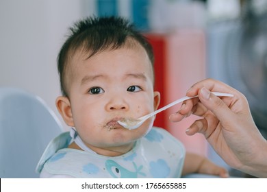 The baby does not want to eat the food that the mother feeds.