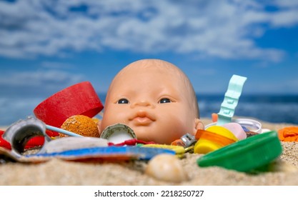 A Baby Doll Head Surrounded By Rubbish And Trash On A Beautiful Beach 