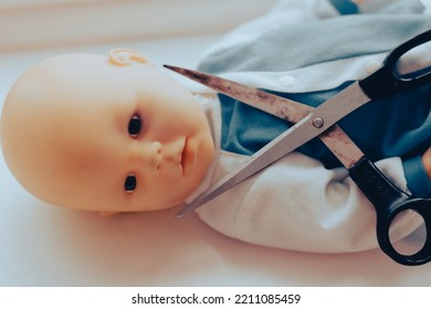 baby doll with scissors. child abuse concept. High quality photo - Shutterstock ID 2211085459