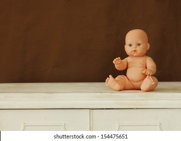 Baby Doll Sitting On Vintage Table